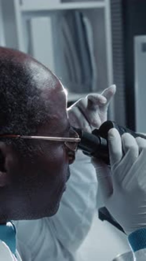 Scientist Using Microscope in Medical Research Lab