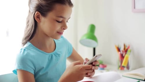 Girl Using Smartphone at Desk in Bright Room
