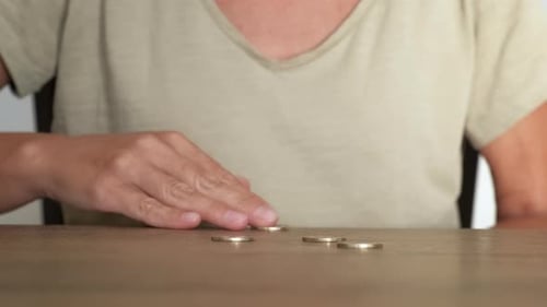 Woman Counting Coins on Table