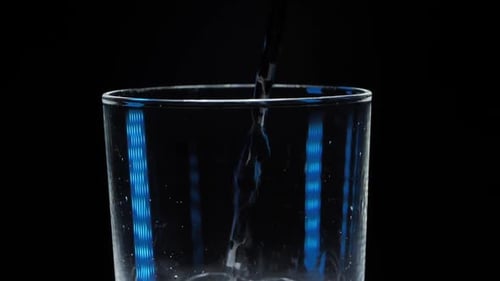 Ein Glas Mineralwasser auf schwarzem Hintergrund. Blasen kommen aus dem Glas. Reines mineralisiertes Wachs