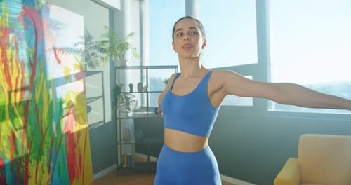 Young Woman Lifts Weights at Home in Sunlight