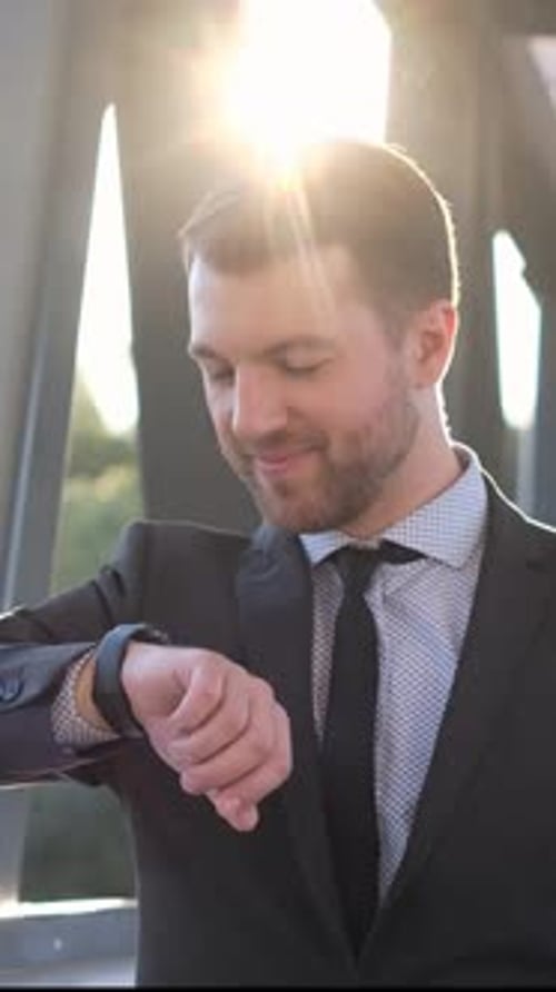 A Welldressed Professional Man in a Tailored Suit is Checking His Stylish Watch While Standing in an