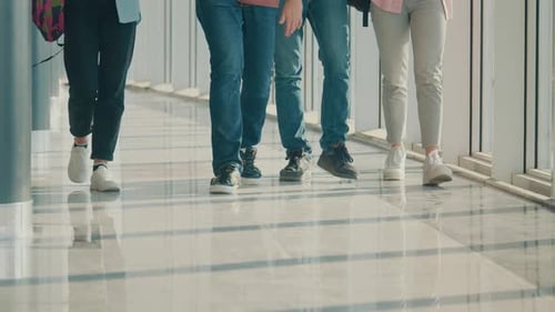 Legs of Students Going By University HallWay During Break