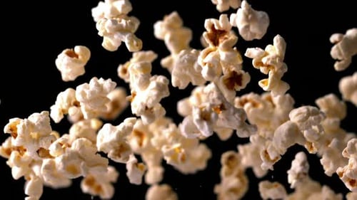 Popcorn bouncing against black background