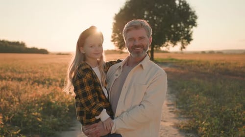 Father and Daughter in Golden Field at Sunset