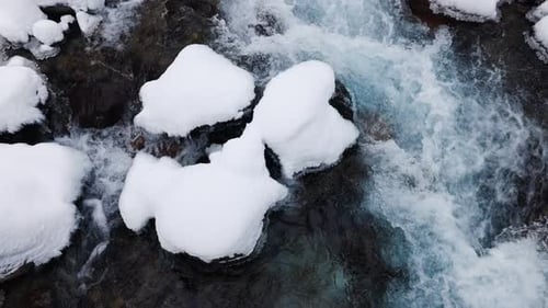 River Stream at Winter Snow Forest in the Mountains