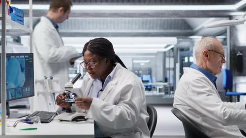Scientist Analyzing Samples in Laboratory Setting with Microscope and Chemicals
