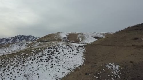 A drone flight over snow capped hills