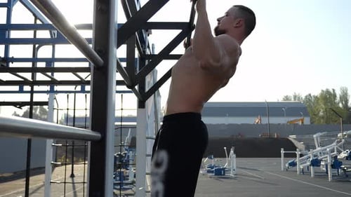 Shirtless Man Doing Pull Ups Outside