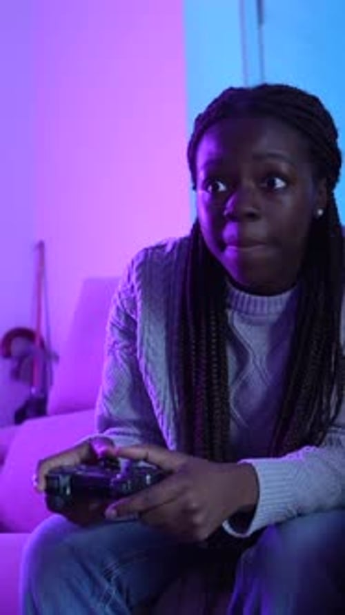 Woman Plays Video Game with Friend on Couch