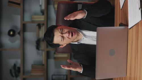 Business Person Closing Laptop with Disappointment in Office