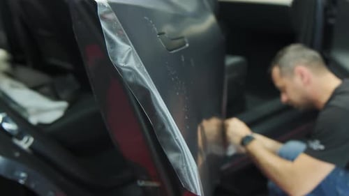 Verfahren zum Aufbringen einer PPF-Schutzfolie auf einen Autoarbeiter Aufbringen einer Schutzfolie auf ein neues Auto