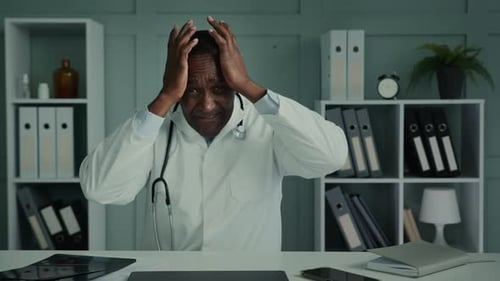 Stressed Doctor with Hands on Head in Office