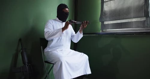 Man in Mask Holding Machete and Gun