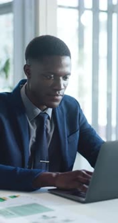 Professional Man Working on Laptop in Modern Office
