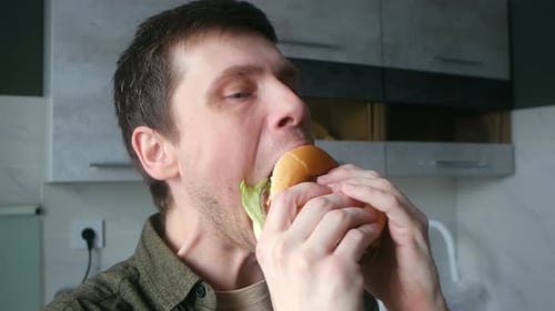 Man Taking a Big Bite of a Burger