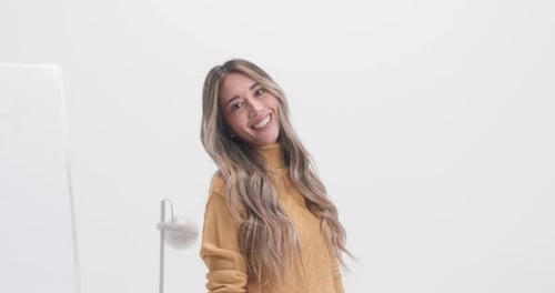 Smiling young woman with long hair in white studio