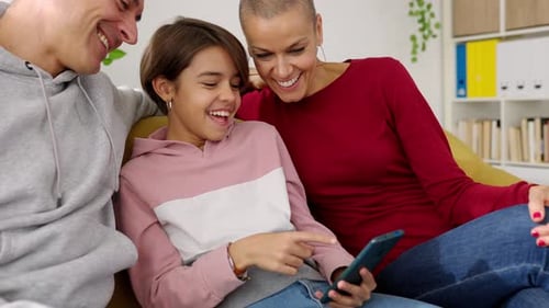 Family Together Laughing at Phone Indoors