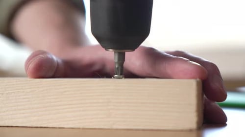 Close Up of Drill Driving Screw into Wood