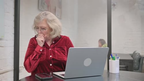Woman with Blond Hair Coughing at a Computer