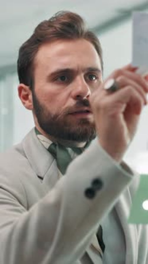 Glass wall, sticky notes and writing with business man in office for brainstorming or strategy