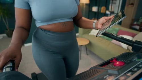 Woman Working Out on Treadmill with Tablet