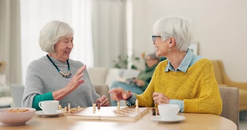 Senior Women Playing Chess and Laughing Together
