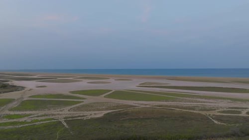 Aerial Shot of Coastal Wetlands at Twilight with Patterns in Sand and Sea