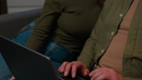 Couple Using Laptop at Home in the Evening