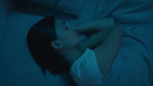 Woman Sleeping in Bed during Night