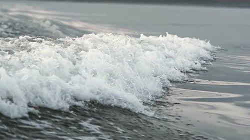 Calm Ocean Waves Crashing Into Soft White Foam at Sea