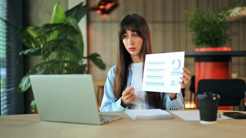 Empresaria dirige una presentación en línea que explica los gráficos de datos en una reunión virtual