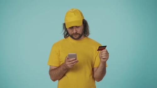 Young Adult Using Credit Card with Phone