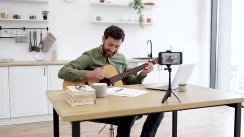 Bloguero graba un vídeo tutorial sobre tocar la guitarra