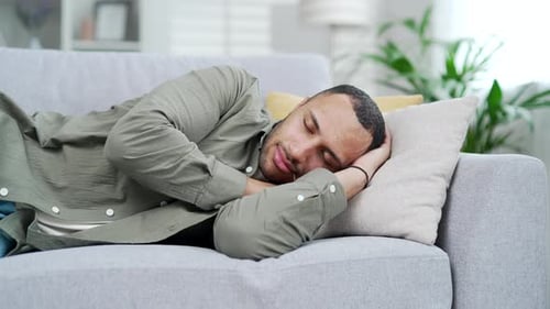 Man Relaxing Asleep on Couch at Home