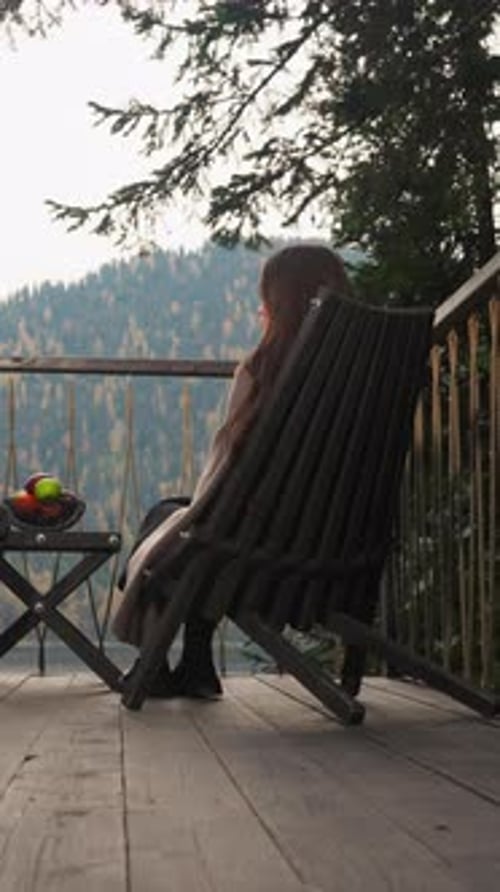 Woman Sitting in Chair on Porch