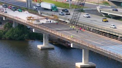 Hardhat Workers on American Highway Bridge Road Under Construction Adding New Lanes to Bridge