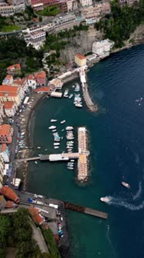 Aerial View of a Harbor with Boats Docked and a City in the Background