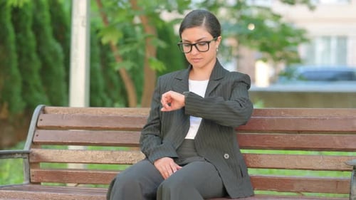 Waiting Indian Businesswoman Checking Wrist Watch on Park Bench
