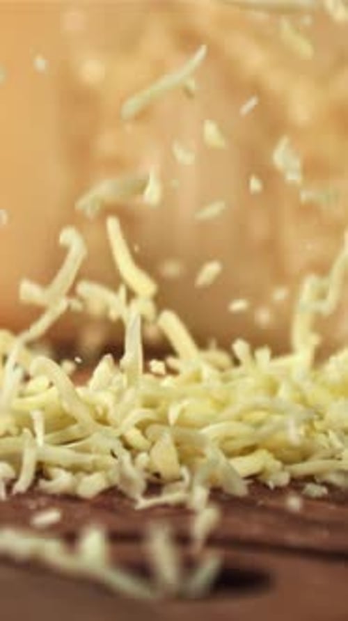 The Grated Cheese Falls on a Wooden Board Filmed on a Highspeed Camera at 1000 Fps