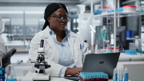 Scientist Typing on Laptop in a Lab