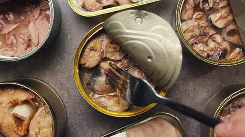 Opening Metal Cans with Canned Fish and Pate on Table Top View Canned Salmon and Tuna Macro Canning