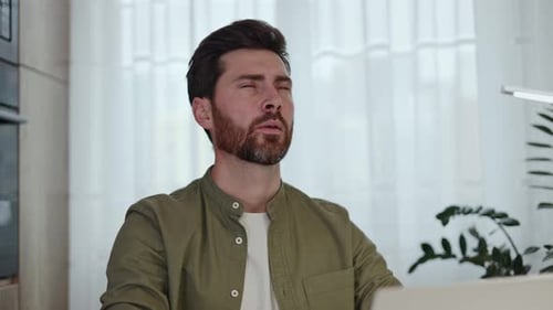 Adult Man Experiences Neck Pain at Desk