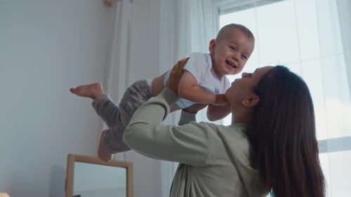Mother holding her happy infant up in the air