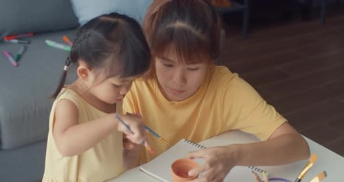 Adult and Child Painting Together at Table