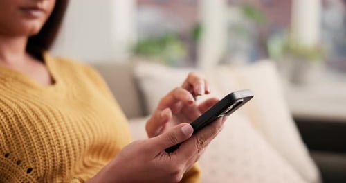 Woman Using a Mobile Phone While Relaxing on Couch