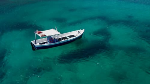 Fishboat in turquoise ocean in greece