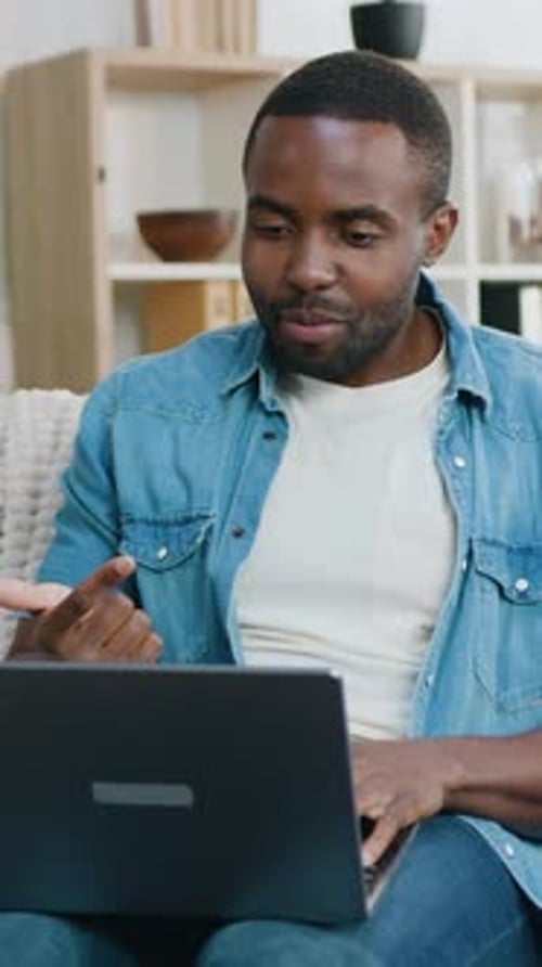 Man Video Conferencing on Laptop at Home