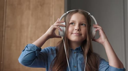 Cheerful girl enjoying music at home with headphones canon cinema eos