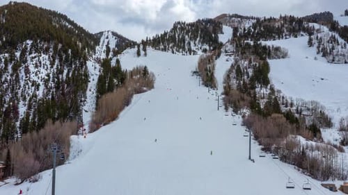 Skiers Skiing At Ski Resort With Ski Lift In Winter in Aspen Colorado - aerial hyperlapse shot